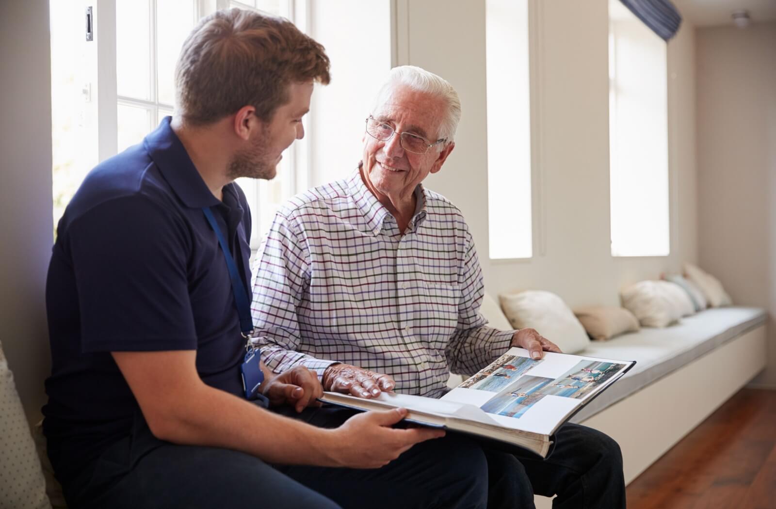 senior and young adult sit and speak
